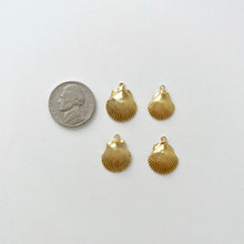 Gold seashell pendants next to a nickel 