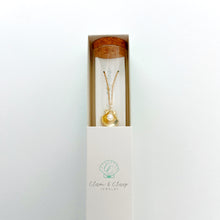 Gold seashell necklace with pearl in a glass bottle and small white box
